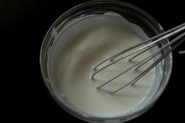 curd being whisked in a bowl