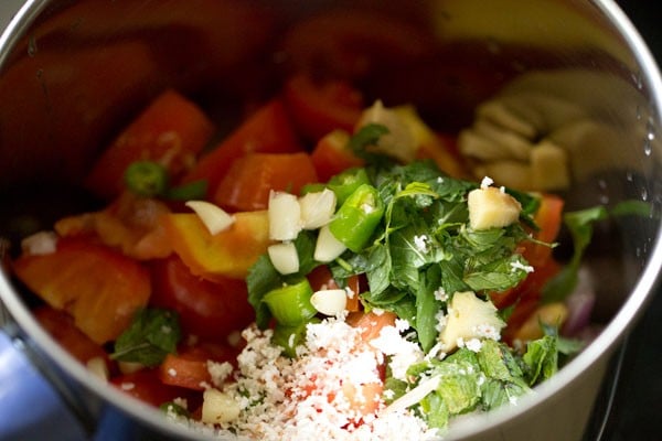 roughly chopped tomatoes, chopped onion, chopped green chili, roughly chopped ginger, chopped garlic, grated fresh coconut and chopped mint leaves added to a blender jar for shorba recipe. 