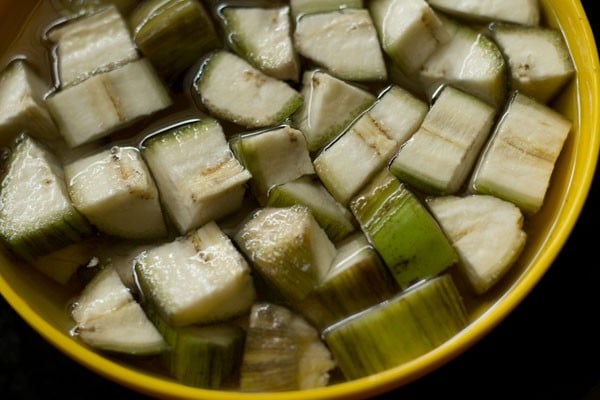 Cut raw banana into cubes and add it to water to make raw banana sabzi. 