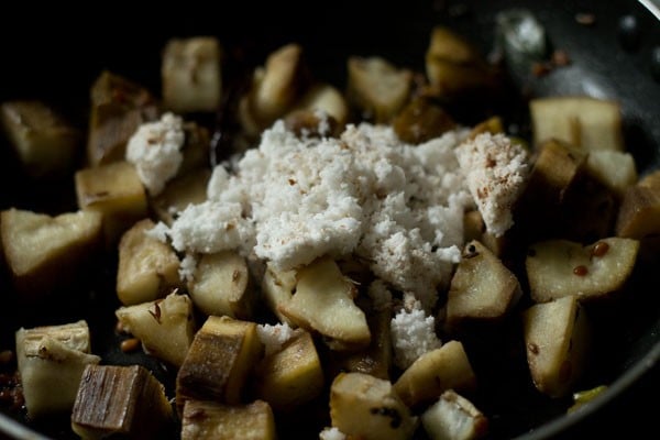 coconut added to raw banana poriyal in the pan