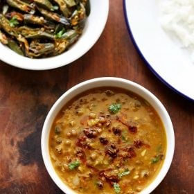 green moong dal in a white bowl on a wooden table.