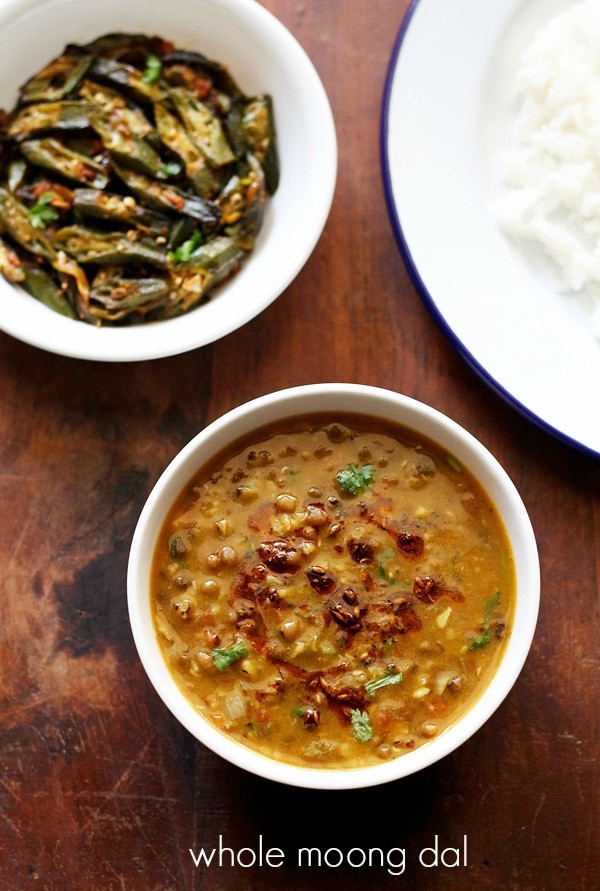 green moong dal in a white bowl on a wooden table.