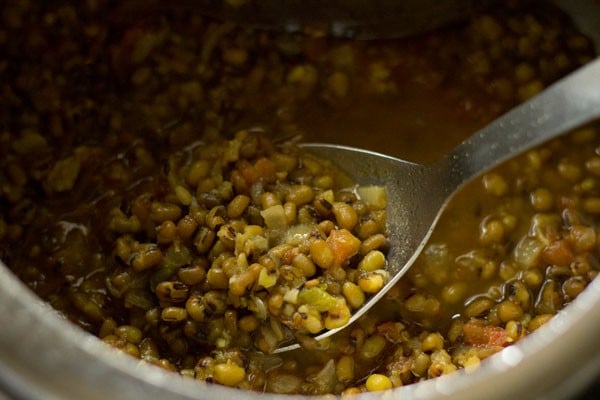 cooked green gram in a spoon.