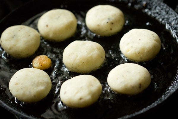 shallow frying prepared aloo kofta in hot oil. 