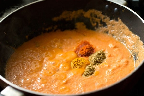 turmeric powder, kashmiri red chili powder and coriander powder added to the masala paste in the pan. 