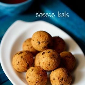 cheese balls served in a white tray on a blue board