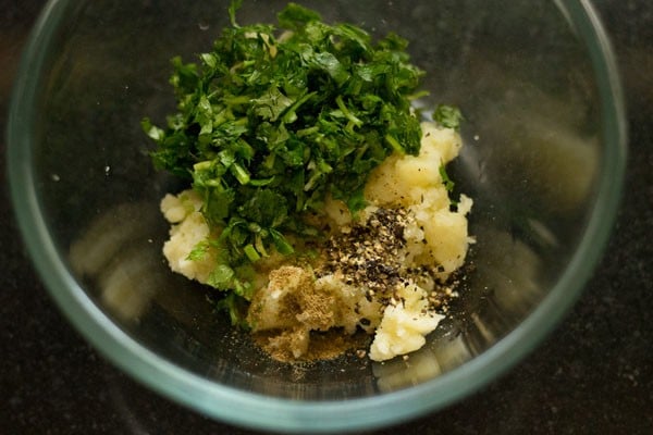 spices added to bowl of mashed potatoes