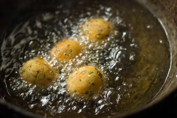 cheese balls are getting some golden color while frying in oil