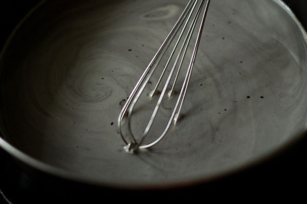 whisking to dissolve jaggery in water