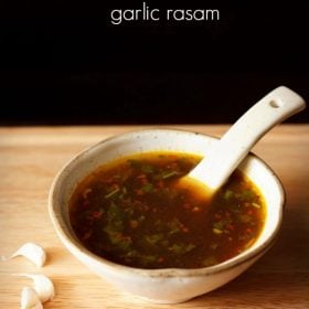 garlic rasam served in a white ceramic bowl with a spoon in it and text layover.