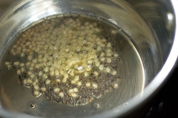 Add mustard seeds and urad dal to hot sesame oil in a pan. 