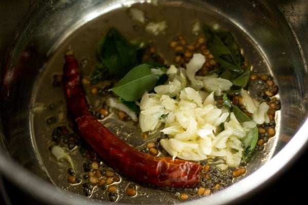 curry leaves, dried red chilies and crushed garlic added to pan for poondu rasam. 