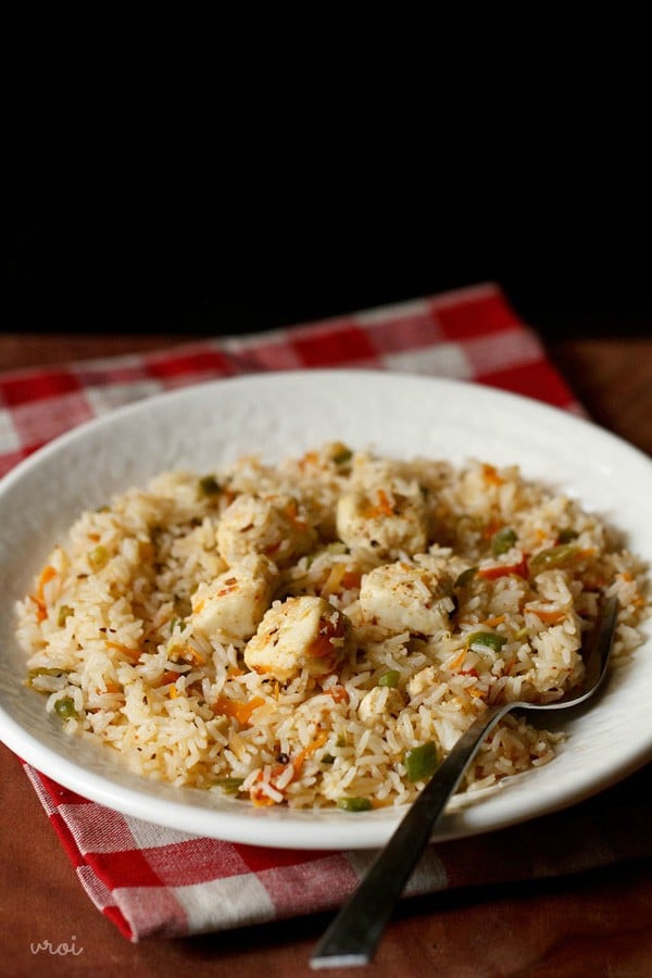 paneer fried rice served in a white plate with a spoon