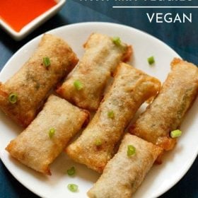 overhead shot of white serving plate with 6 crispy fried veg spring rolls garnished with green onions with text layovers