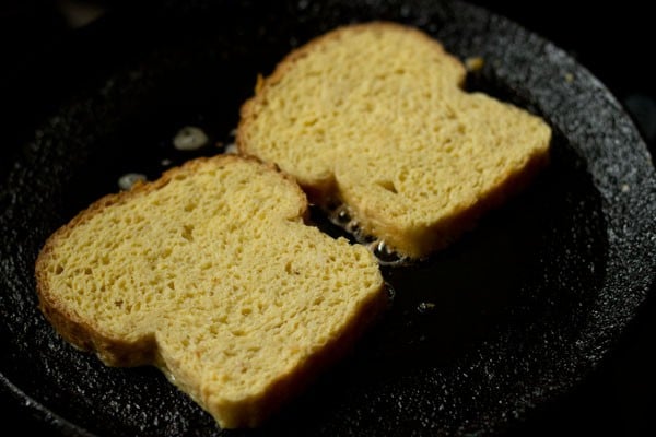 toasting two bread slices till evenly golden from both the sides to make french toast without eggs.