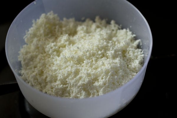 finely grated paneer in a mixing bowl.