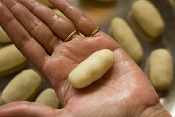 rolling kala jamuns into oblong shapes.