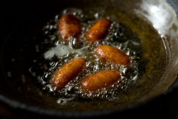 frying kala jamuns are becoming darker.