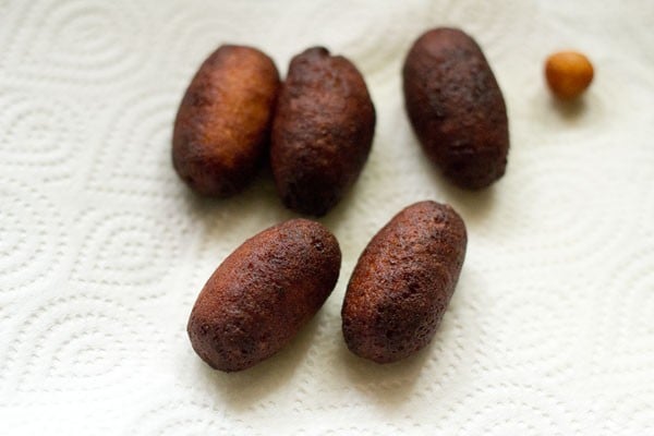 draining fried kala jamun on a paper towel to remove excess oil.