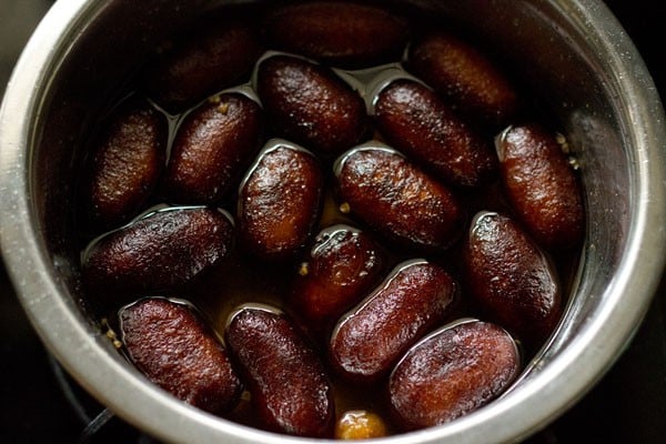 soaking fried kala jamun in prepared sugar syrup.