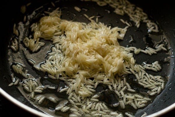 sautéing rice grains for making paal payasam. 