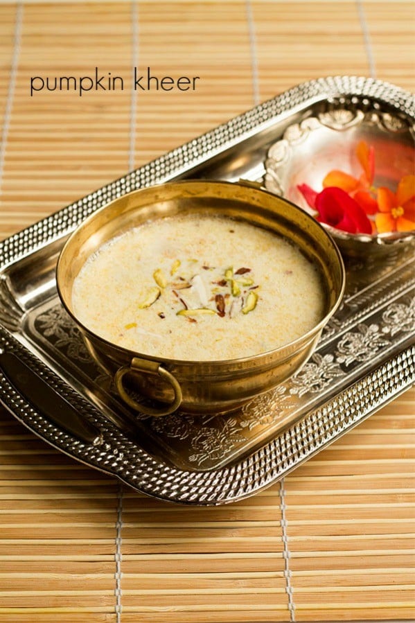 kaddu ki kheer in a decorative brass bowl on a silver tray with flowers in another bowl for offering to the Goddess.