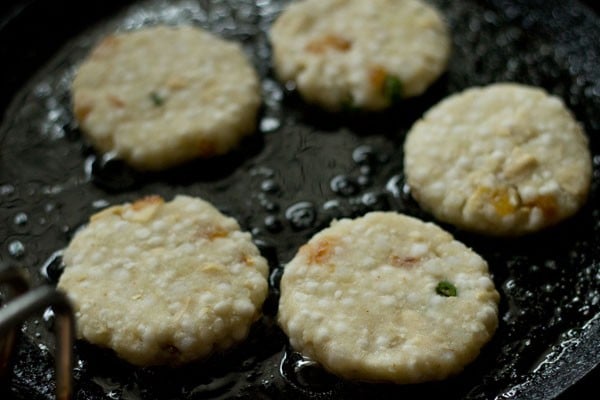 frying sabudana tikki in peanut oil in a pan