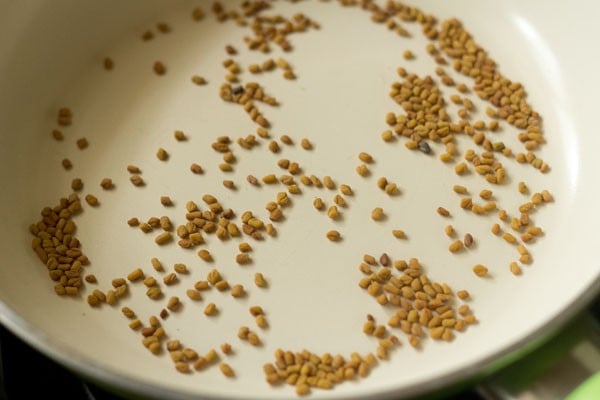 methi seeds added to pan for toasting and making sambar powder recipe