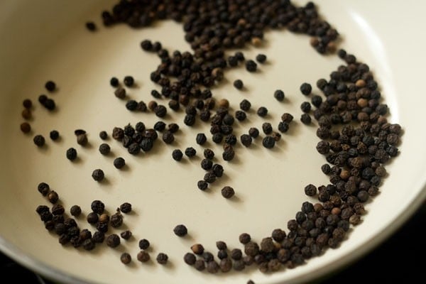 whole black peppercorns in a dry pan