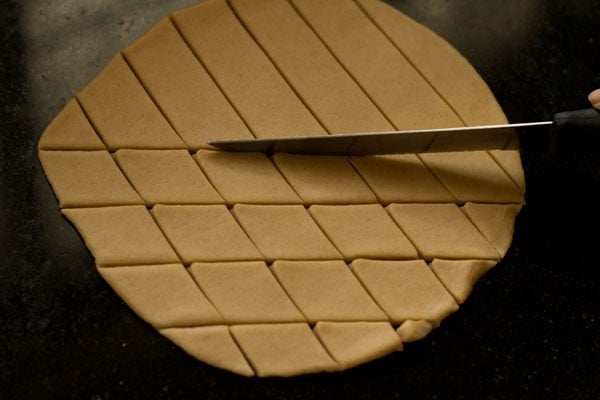 making diamonds using a knife on the rolled dough paratha. 