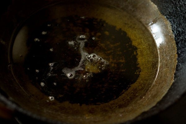 heating oil in a pan for deep frying shakkarpare. 