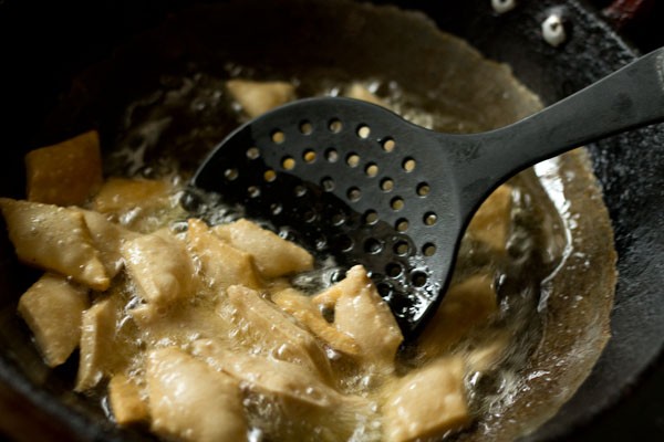 frying shakkarpare by turning them. 