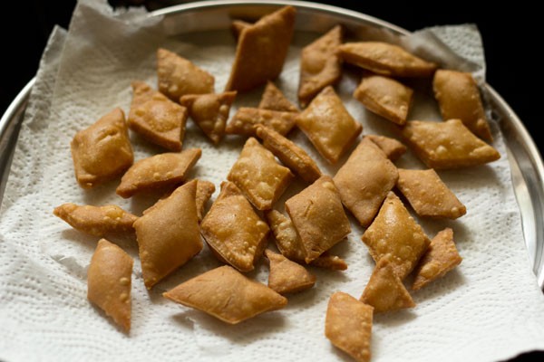 fried shakkarpara placed on kitchen paper towels. 