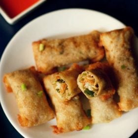 spring rolls on a white plate with halved roll showing the vegetable filling inside