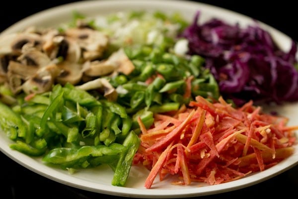 white plate of different vegetables for making spring rolls