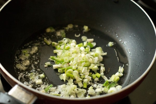 spring onions sautéing in a pan with oil