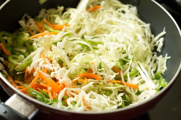verduras ralladas agregadas a la sartén con aceite y cebollas verdes