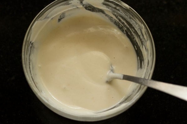 spoon in a bowl with the paste for sealing vegetable spring rolls