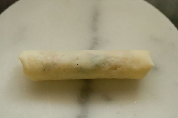 rolled spring roll with seam facing down before sealing sides