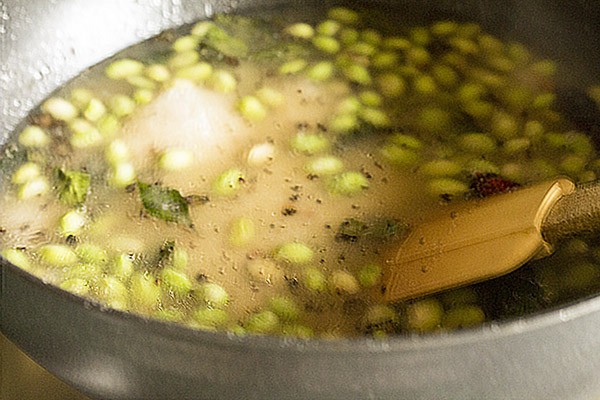 stirring ground rice-pepper mixture into the lilva beans.