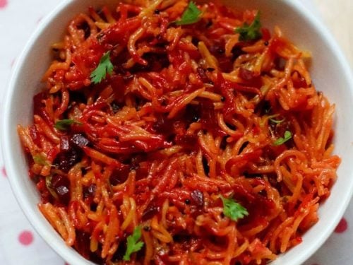 beetroot rice garnished with coriander leaves and served in a white bowl.