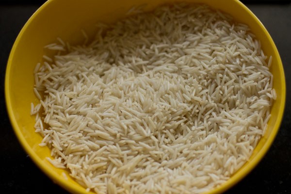 basmati rice in a yellow bowl for making beetroot rice recipe.