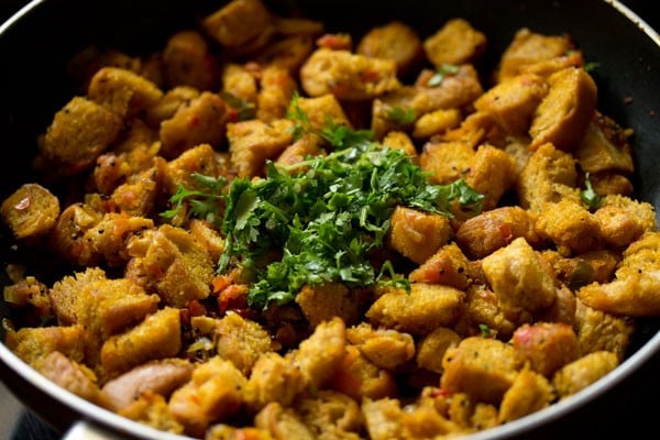 bread upma garnished with coriander leaves in the pan