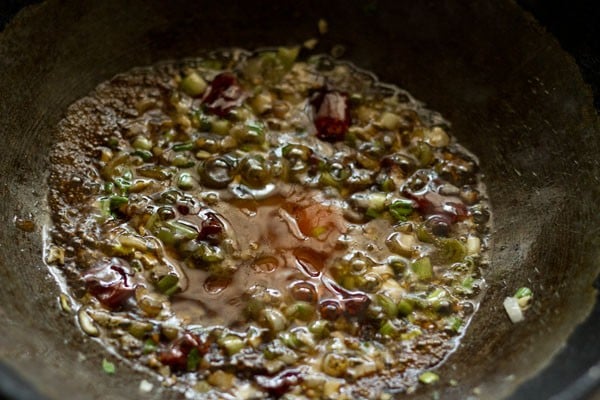 adding spicy sauces to the wok