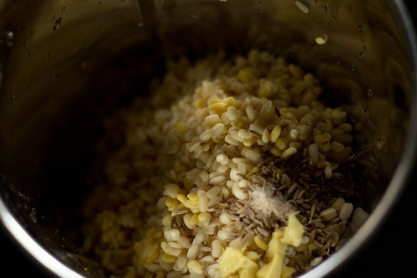 drained dals, cumin seeds and asafoetida added to grinder jar. 