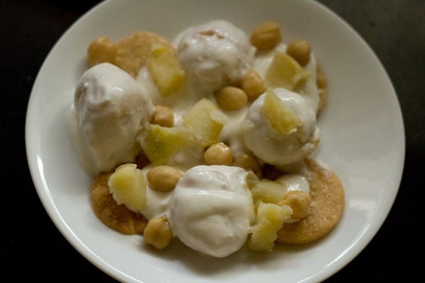 dahi bhalla topped with boiled potatoes and boiled chickpeas. 