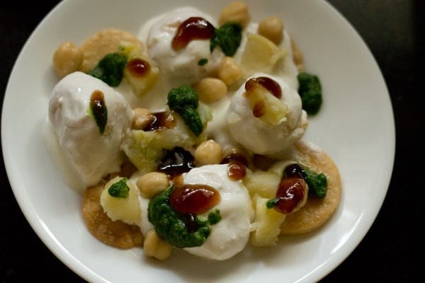 green chutney and tamarind chutney added on the dahi bhalla. 