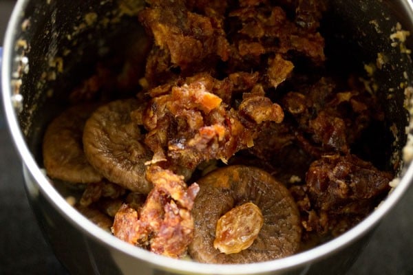 figs, raisins, and dates added to grinder jar for making dry fruits burfi recipe.