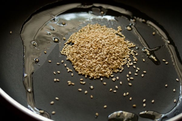 sesame seeds toasting in a pan with oil.