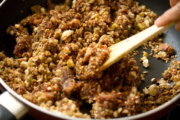 stirring dry fruits burfi mixture.